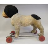 A vintage Steiff pull-along toy dog 'Bully' on a painted steel frame with steering front wheels