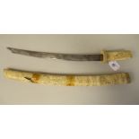 A 19thC Japanese intricately carved bone handled short sword/dagger with a matching scabbard  the