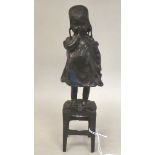 A 20thC cast and patinated bronze figure, a Dutch girl holding a shoe and standing on a stool  12"h