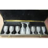 A presentation set of six engraved and cut glass pedestal goblets and a pair of matching decanters