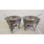 A pair of late 19thC Empire style white metal fluted salt cellars with clear star cut glass