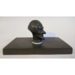 A late 19thC cast and patinated bronze paperweight, featuring a man's head, believed to be that of