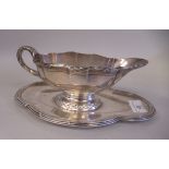 A Rissler & Carr of Paris silver coloured metal sauce boat, on an oval tray  9"w  bears regional