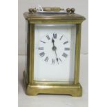 An early 20thC brass cased carriage timepiece with a folding top and bevelled glass panels; the