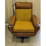 A 1960s/1970s stitched tan coloured hide teak framed swivel arm chair