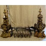 A pair of early 20thC cast brass fire dogs  21"h  21"deep; a cast iron fire grate and steel irons