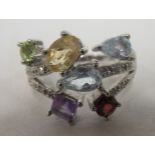 A modern 9ct white gold ring, claw set with various coloured stones