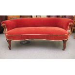 A late Victorian walnut showwood framed round back boudoir settee, upholstered in orange fabric,