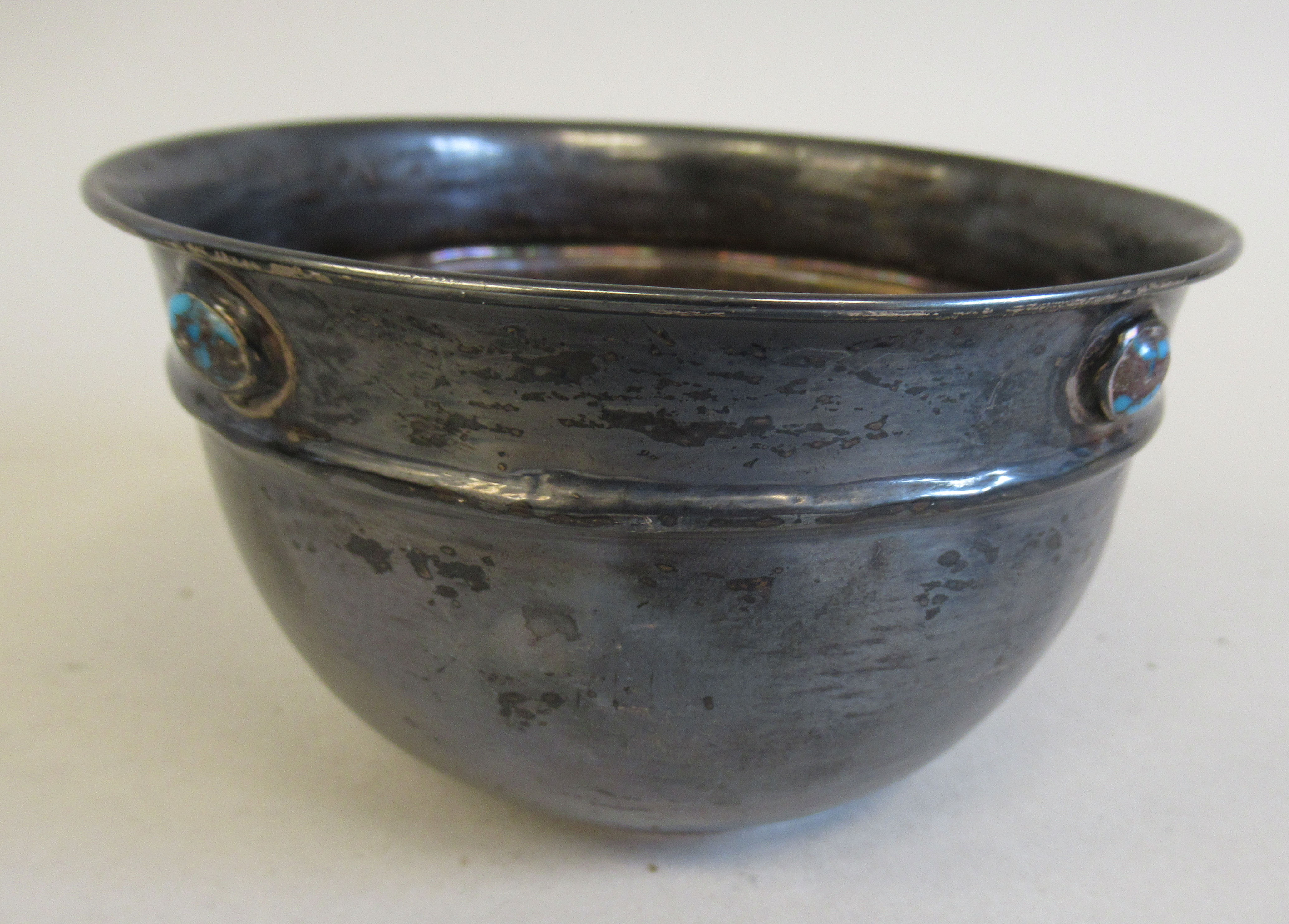 An Art Nouveau silver bowl with a rolled rim and a frieze of four uniformly spaced turquoise
