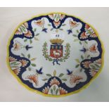 An early 20thC European pottery plate naively painted with an armorial and floral designs  bears