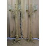 A pair of modern shabby chic painted cast metal four branch uplighters, raised on splayed C-scrolled