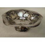 An early 20thC Art Nouveau silver coloured metal tazza, the shallow wavy edged bowl with embossed