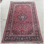 A Persian rug decorated with floral designs on a multi-coloured ground  52" x 82"