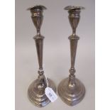 A pair of loaded silver candlesticks of oval outline, each with a detachable sconce in a vase shaped