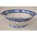 An early 19thC pearlware oval twin handled basket with open latticework sides, decorated in blue and