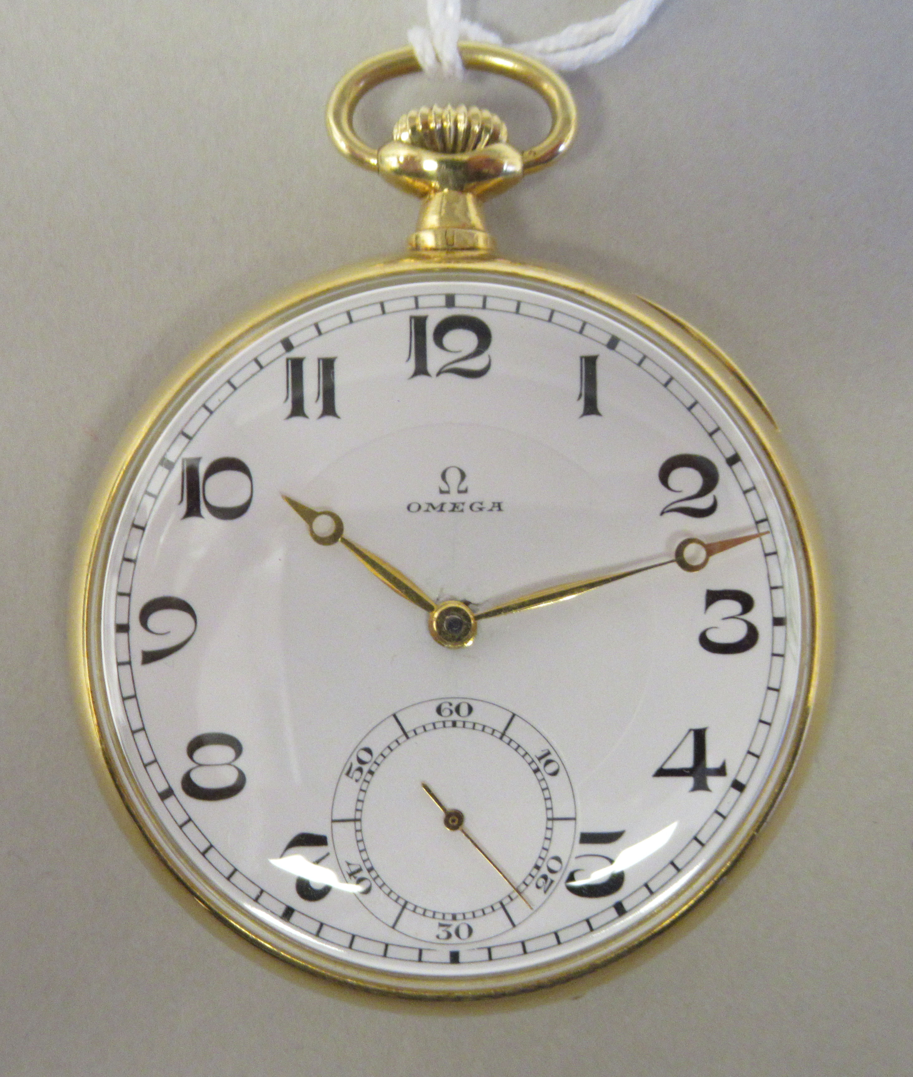 An Omega 18ct gold cased pocket watch with an engine turned back, faced by a white enamel Arabic