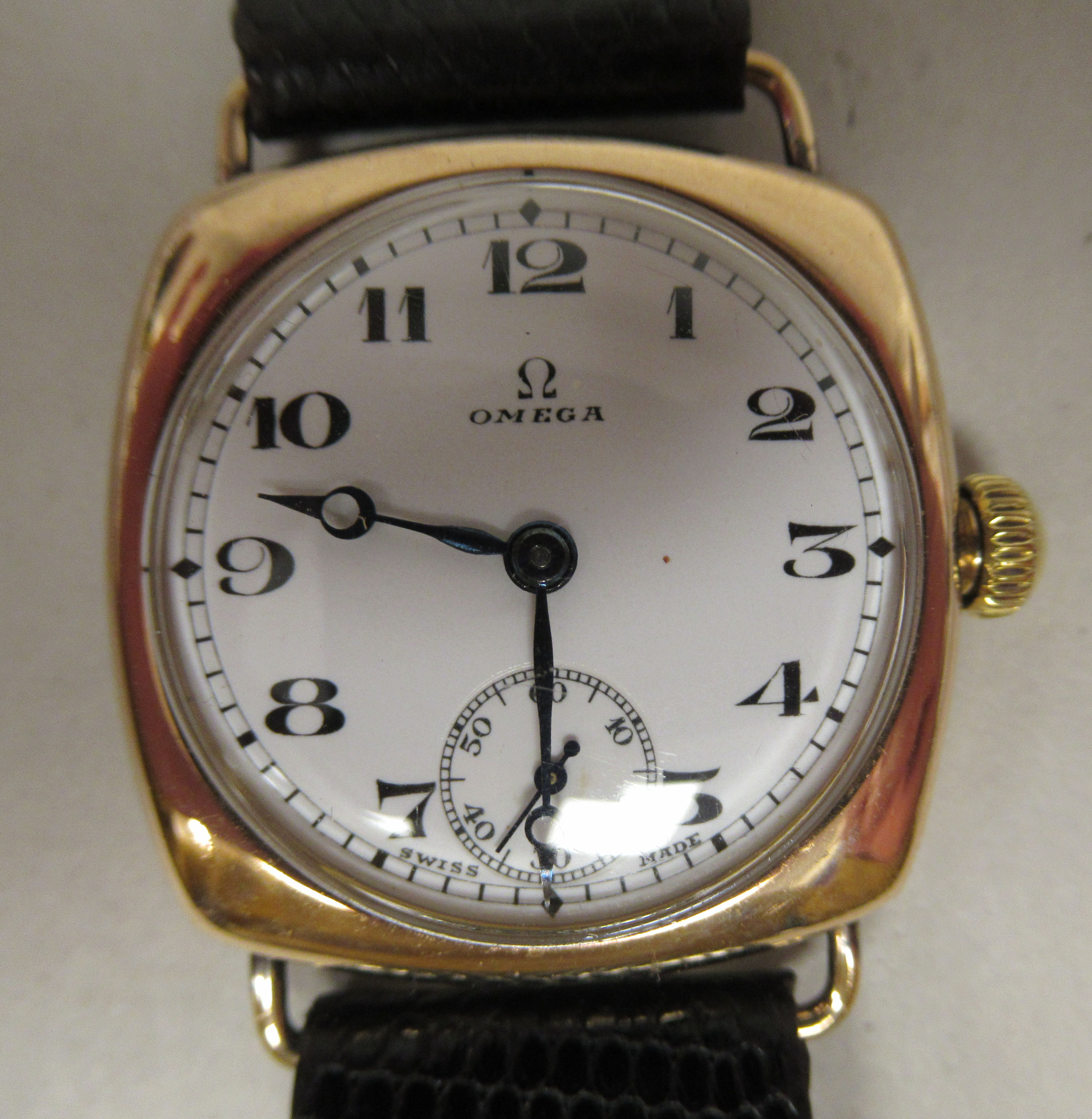 A 1930/40s Omega 9ct gold cushion cased wristwatch, faced by a white enamel Arabic dial,