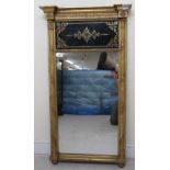 A Regency pier glass, set in a carved gilt gesso frame and incorporating a back painted glass header