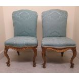 A pair of 19thC carved gilt gesso framed salon chairs with arched backs and serpentine front