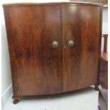 An Art Deco inspired walnut finished bow front, freestanding bar with extending, hinged flaps,