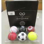 A set of six Golf Genius novelty golf balls, respectively fashioned as a football, tennis ball,