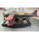 A modern scratch built, turned and painted aeroplane, on a rocking plinth  13"h 30"w