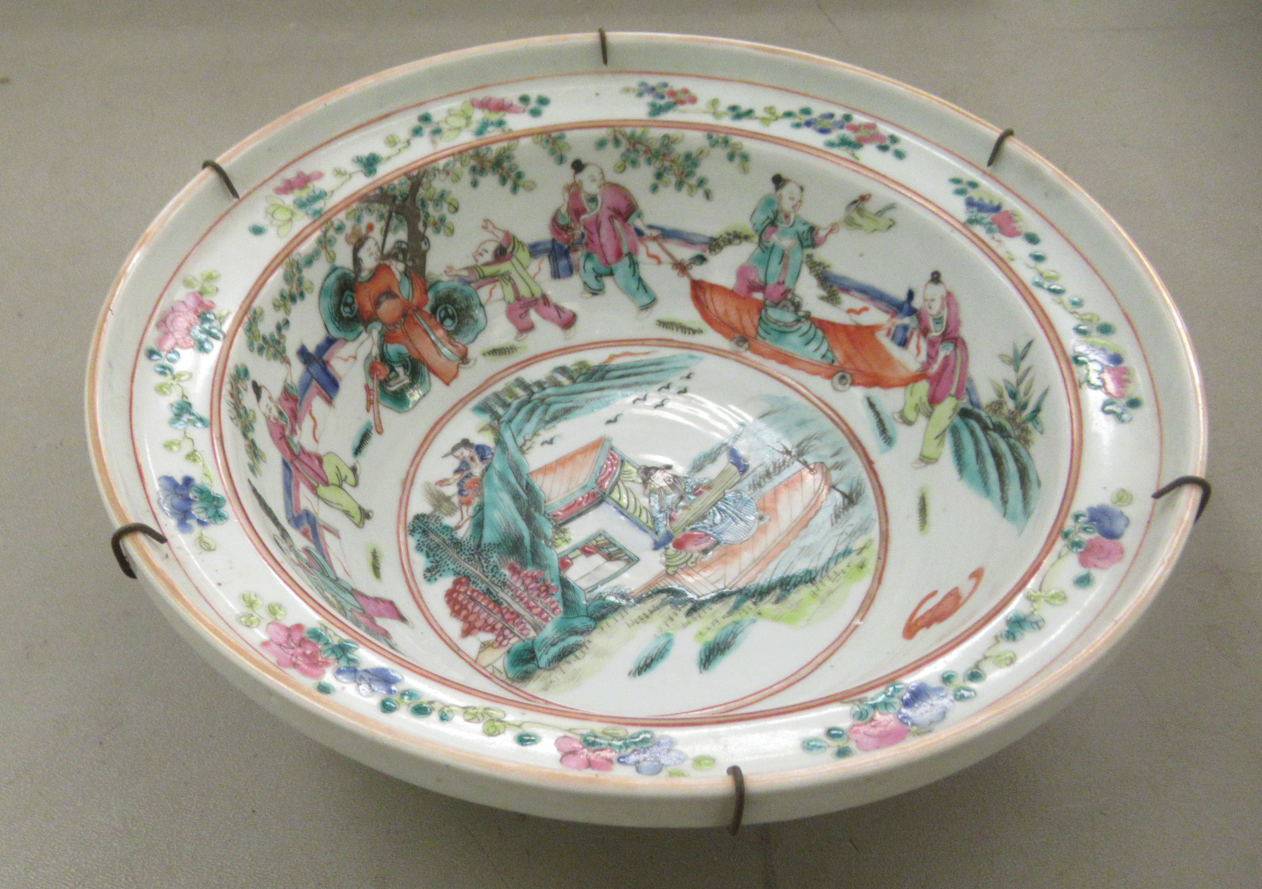 A 19thC Chinese porcelain bowl, having an upstand rim, decorated in recreational figures, bat motifs