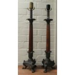A pair of modern table lamps, fashioned as tapered, fluted capitals, on cast metal tripod bases
