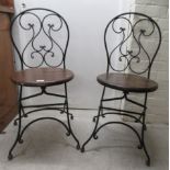 A pair of modern wrought iron framed folding terrace chairs