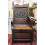 A late 18th/early 19thC carved, stained and panelled oak lambing chair with a hinged seat, raised on