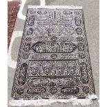 An Arabic rug, depicting text, white on black  40" x 62"