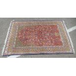 A Persian rug, decorated with repeating floral designs, on a multi-coloured ground  48" x 74"
