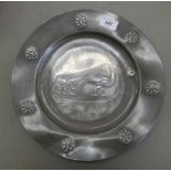 An early 20thC Arts & Crafts Tudric pewter charger, decorated with a peacock  13"dia