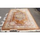 A Chinese washed woollen rug, traditionally decorated with flora and foliage, in pastel tones, on