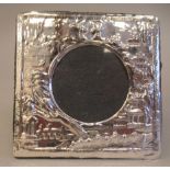 A Victorian style silver coloured metal photograph frame with embossed decoration and a circular