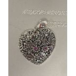 A Sterling silver and ruby set heart shaped pendant, on a fine neckchain