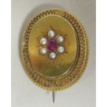 A late Victorian yellow metal mourning brooch, set with a ruby and seed pearls