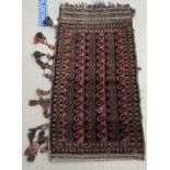 A Caucasian saddle rug with pole medallions, on a black and iron red ground  44" x 26"