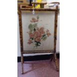 An early 20thC bamboo framed firescreen, set with a floral painted glass panel  28"h  19"w