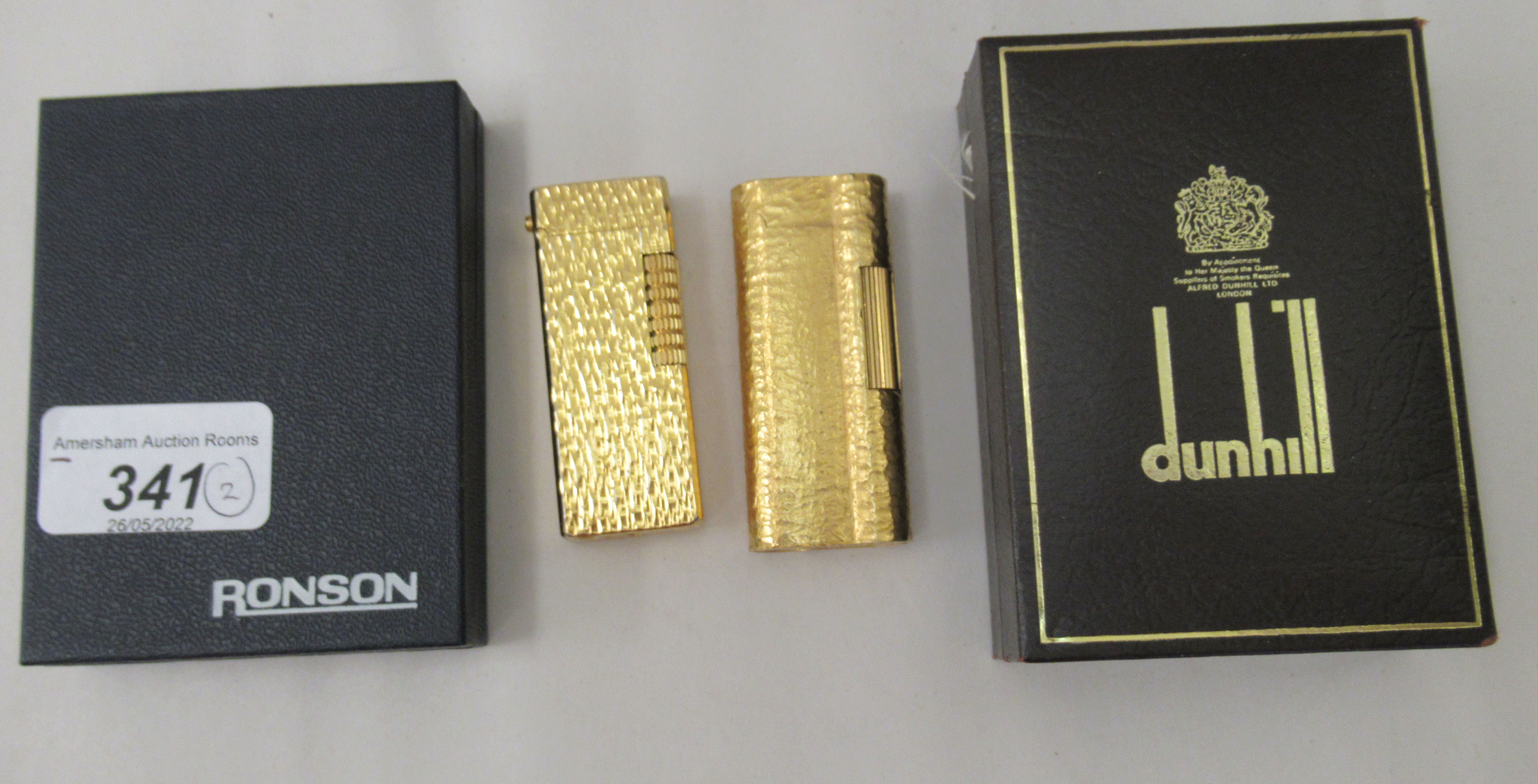 A gold plated Dunhill lighter, model no.C62814; and another gold plated example