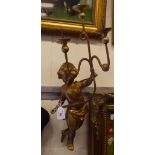 A late 19thC gilded softwood applique, fashioned as a cherubic figure, holding a three branch picket