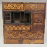 A circa 1900 Japanese tabletop samplewood cabinet, decorated in a variety of veneers with
