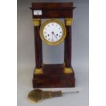 A French Empire mahogany and decoratively cast gilt metal mounted portico clock, the four turned