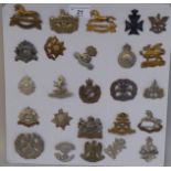 Twenty-five military regimental cap badges and other insignia, some copies: to include The