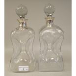 A pair of 1950s glass cluck-cluck decanters with ground stoppers and applied silver collars  Asprey,