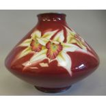 A 20thC iron red enamel vase of squat, angular bulbous form, decorated in colours with floral