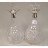 A pair of decoratively cut crystal decanters of bulbous form with mushroom shape stoppers and