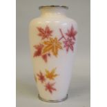 A 20thC peach coloured enamel vase of baluster form, decorated in red and orange with foliate