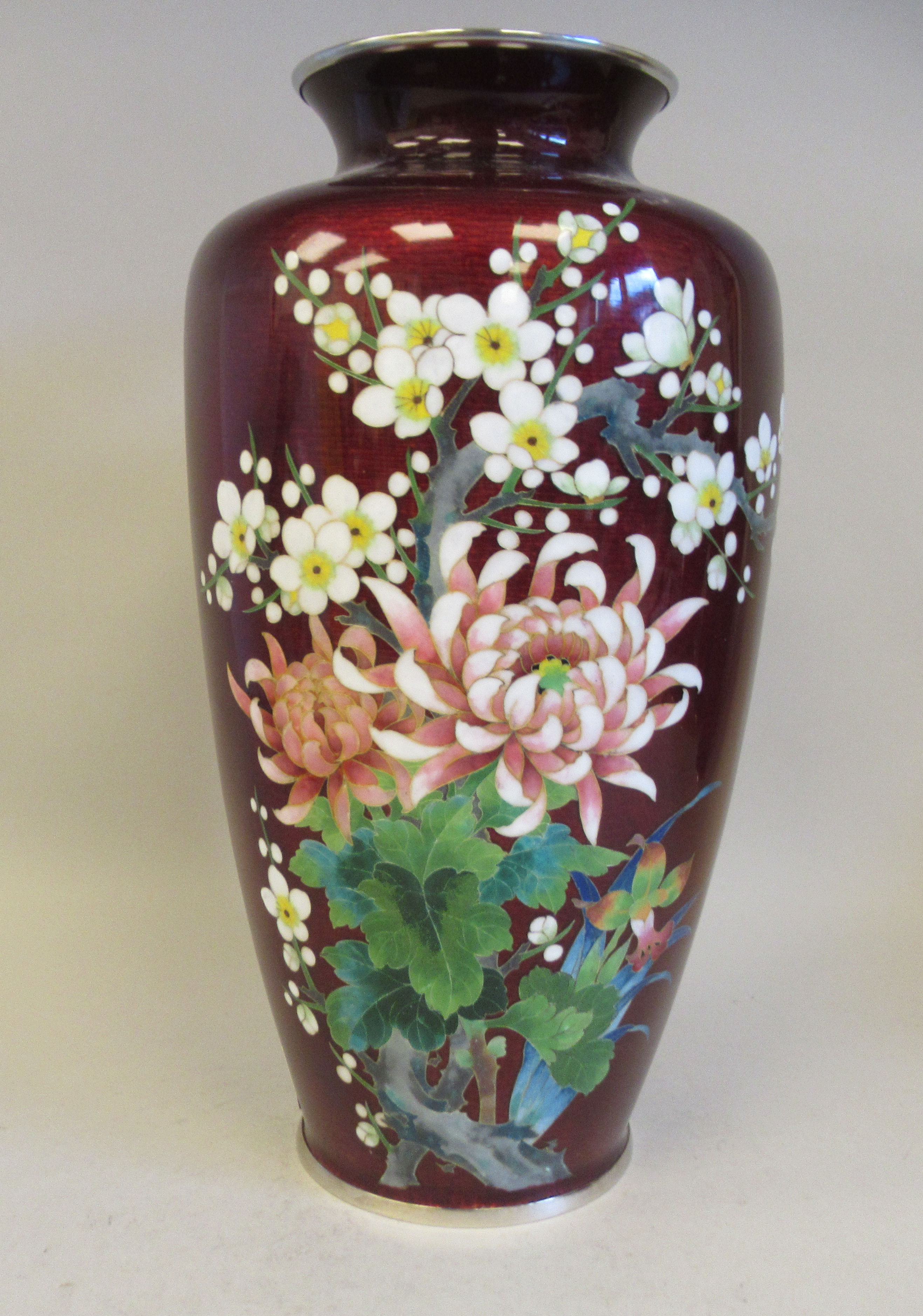 A 20thC oxblood coloured enamel vase of shouldered baluster form, decorated in colours with