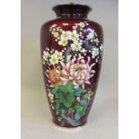 A 20thC oxblood coloured enamel vase of shouldered baluster form, decorated in colours with